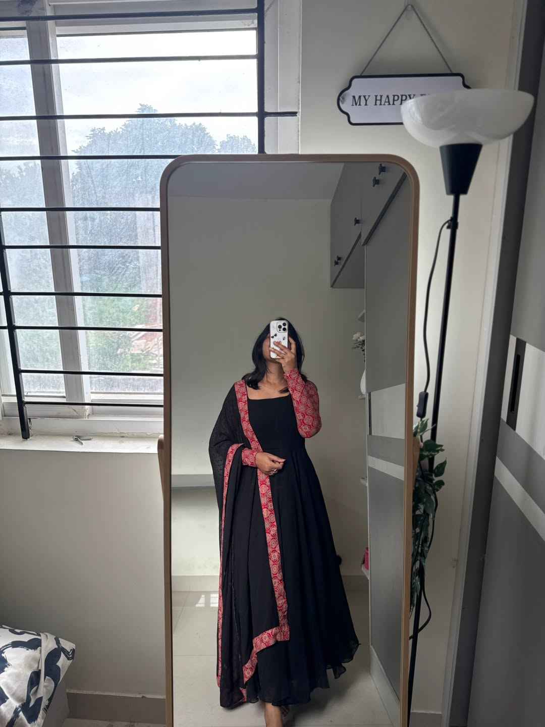 stunning portrait of a young woman exuding grace and poise in a traditional black Anarkali outfit.