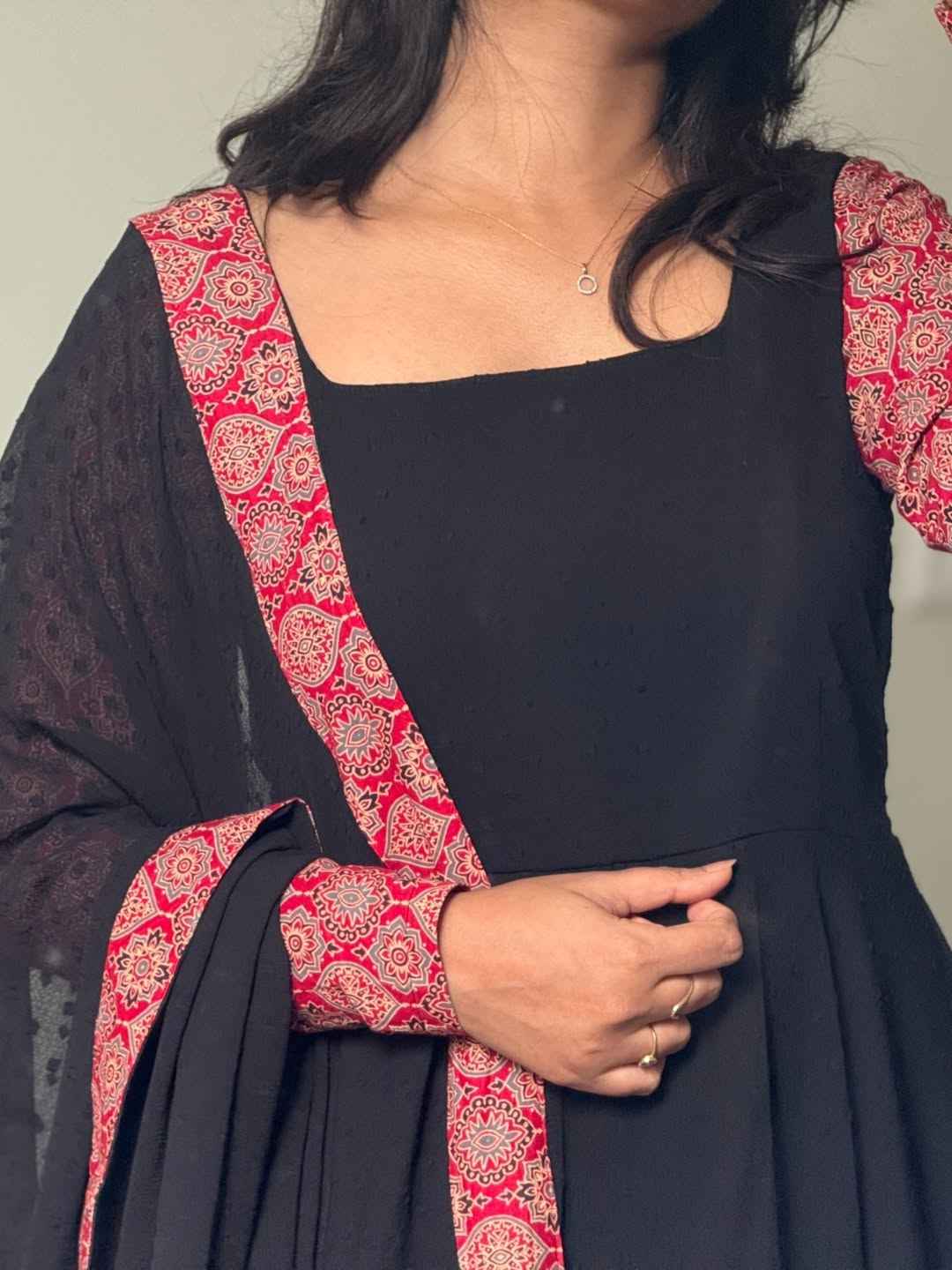 stunning portrait of a young woman exuding grace and poise in a traditional black Anarkali outfit.