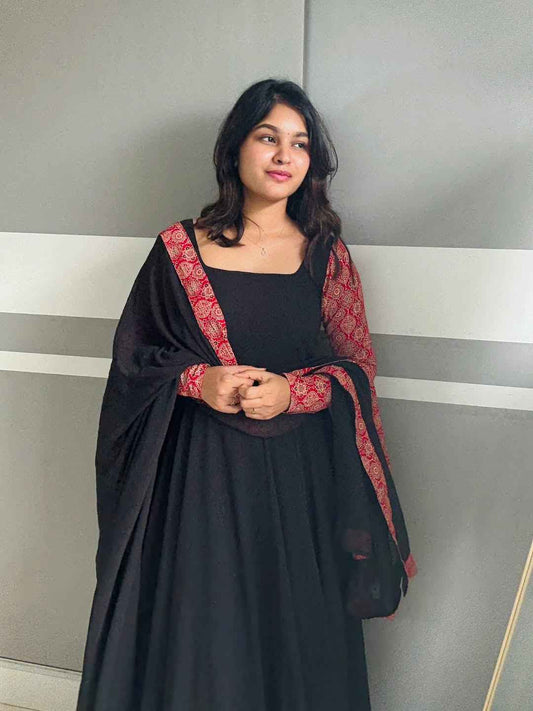 stunning portrait of a young woman exuding grace and poise in a traditional black Anarkali outfit.
