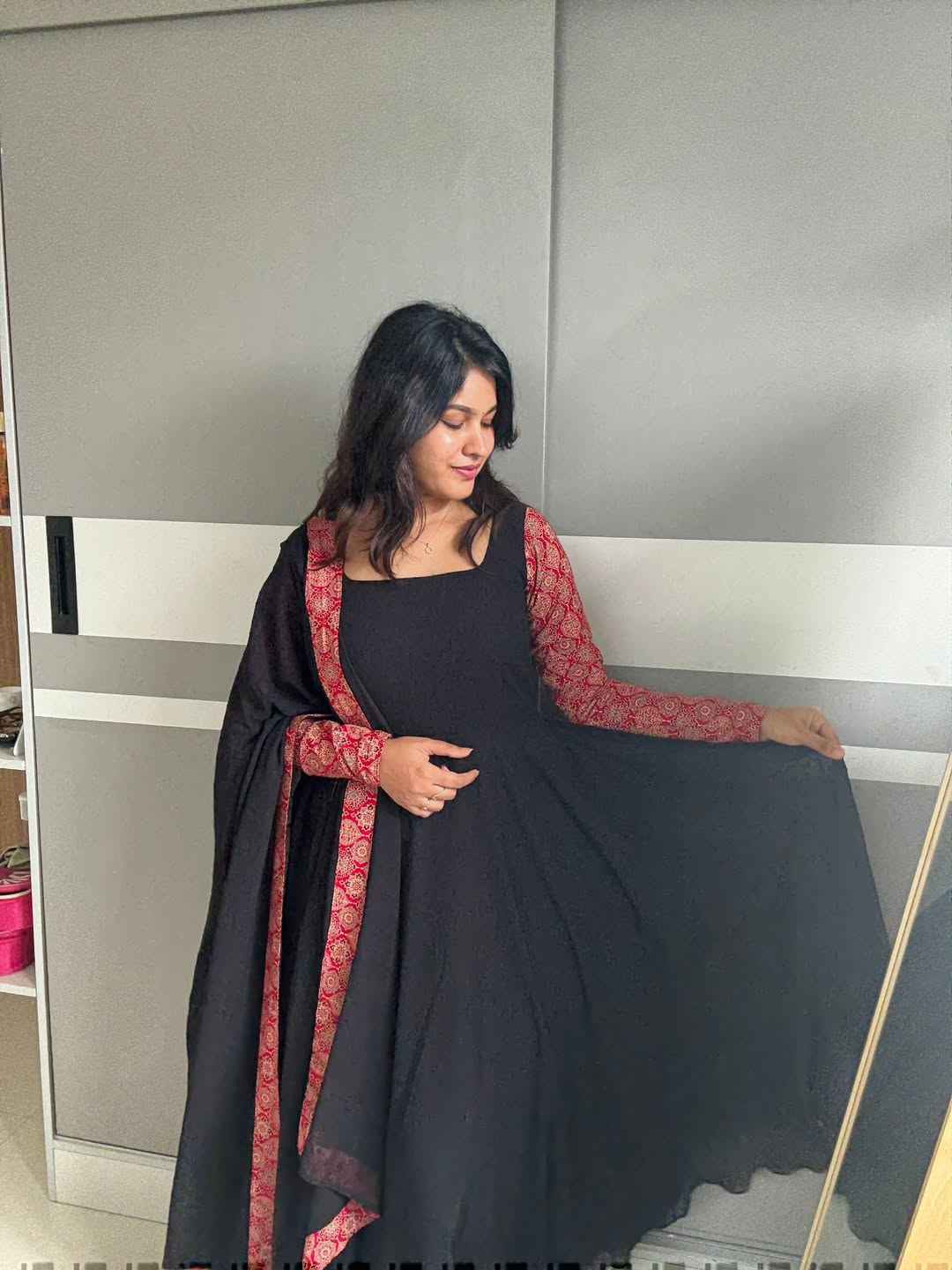 stunning portrait of a young woman exuding grace and poise in a traditional black Anarkali outfit.